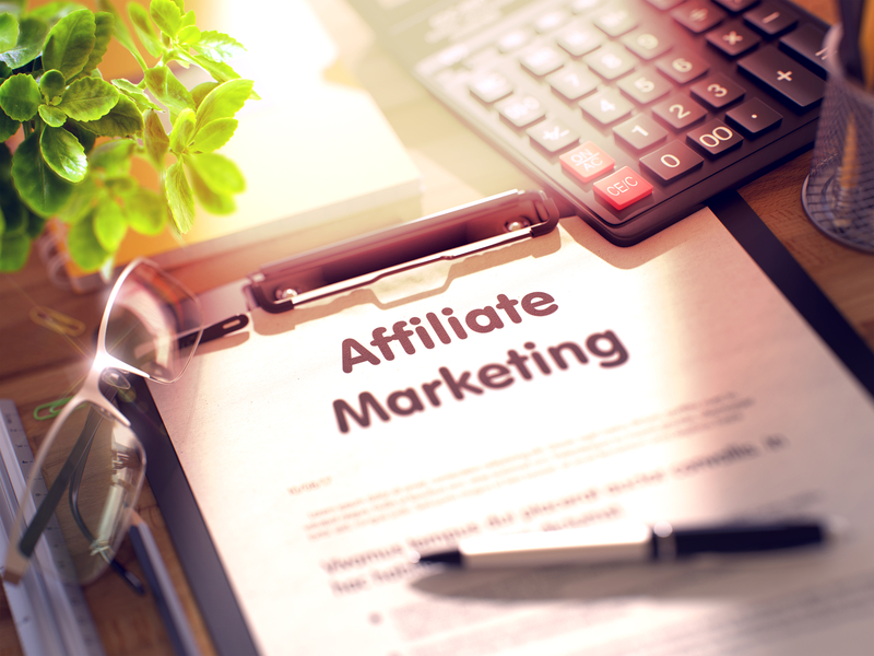 Illustration shows the words, "affiliate marketing" written on a notepad.